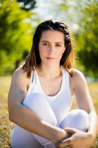 Retrato de una hermosa mujer sentada en la hierba — Foto de Stock