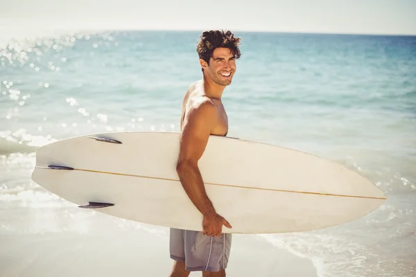 Man anläggningen surfbräda på stranden — Stockfoto