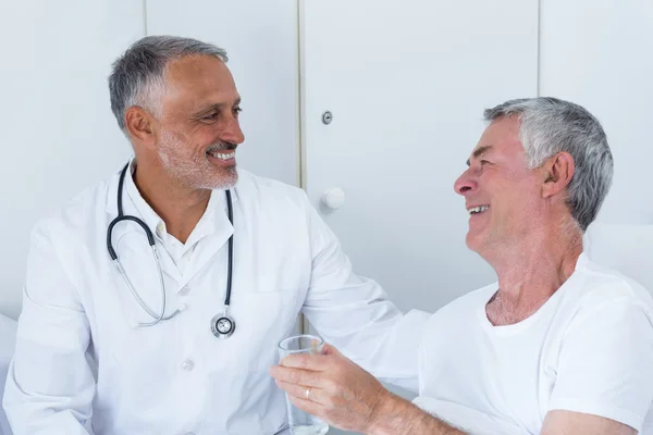 Médico masculino e homem idoso interagindo uns com os outros — Fotografia de Stock