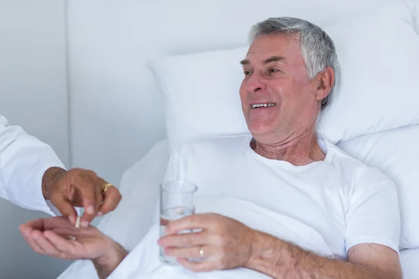 Mannelijke arts pil geven senior man — Stockfoto