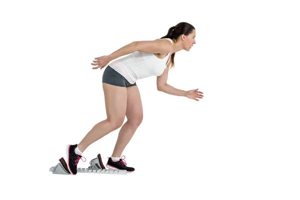 Confident athlete woman running from starting blocks — Stock Photo, Image
