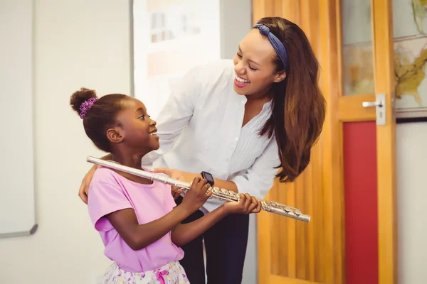 Flüt çalmak için bir kız yardımcı öğretmen — Stok fotoğraf
