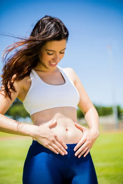 Mulher bonita tocando sua barriga — Fotografia de Stock