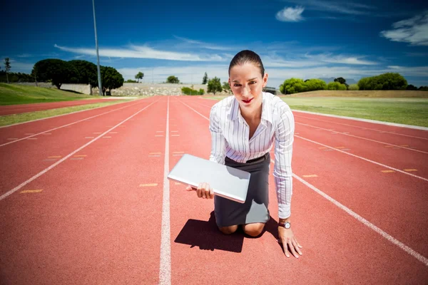 Empresária pronta para correr com um laptop — Fotografia de Stock