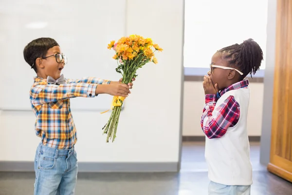 Colegial dando flores a la niña —  Fotos de Stock