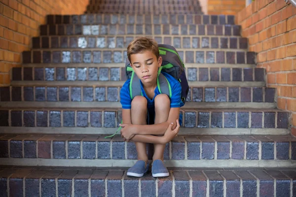 Triest schooljongen zitten in trap — Stockfoto