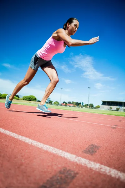 Atleta feminino correndo na pista de corrida — Fotografia de Stock