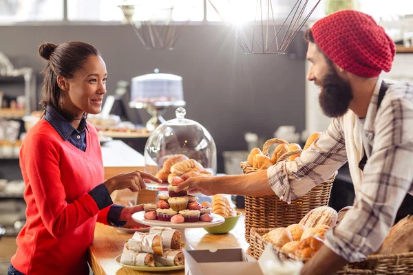 Venditore che serve torta al cliente — Foto Stock