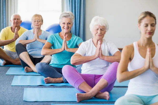 Instruktör utför yoga med seniorer — Stockfoto