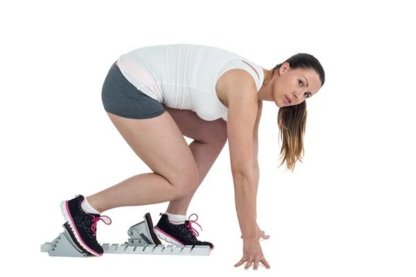 Confident athlete woman running from starting blocks — Stock Photo, Image