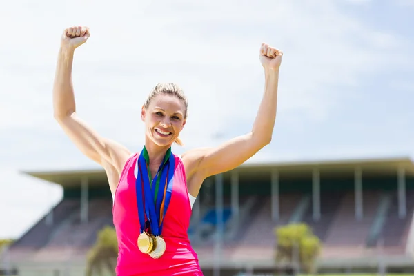 Aufgeregte Athletin mit Goldmedaillen um den Hals — Stockfoto