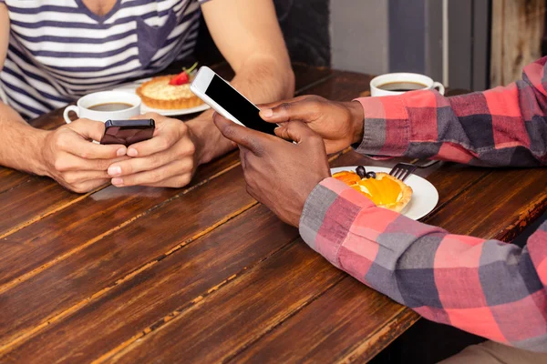 Amigos usando teléfonos inteligentes — Foto de Stock