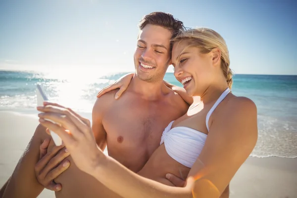 Ungt par med selfie på stranden — Stockfoto