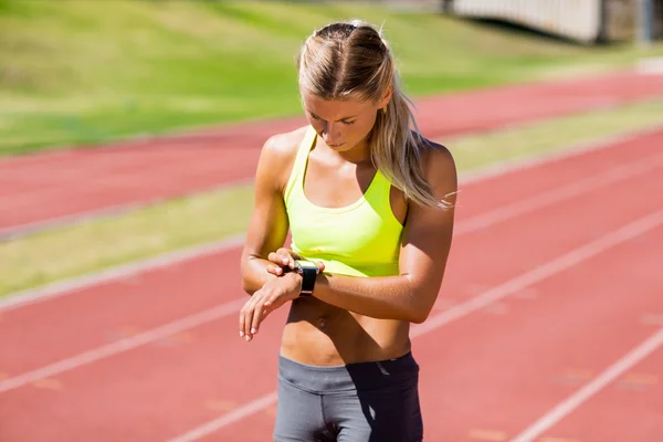 Vrouwelijke atleet, haar slimme horloge controleren — Stockfoto