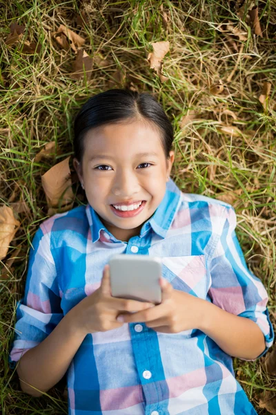 Dívka na trávě pomocí telefonu — Stock fotografie