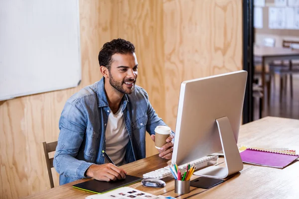 Geschäftsmann lächelt und macht sich Notizen — Stockfoto