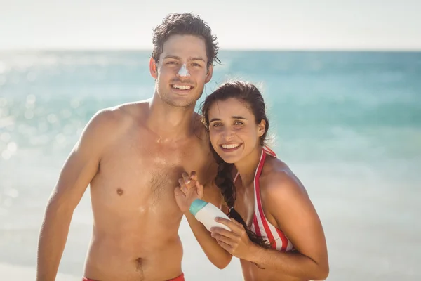 Coppia con crema solare lozione sulla spiaggia — Foto Stock