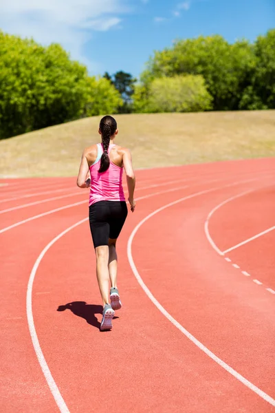 Visão traseira do atleta feminino correndo na pista de corrida — Fotografia de Stock