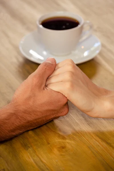 Par hålla händerna i cafeterian — Stockfoto