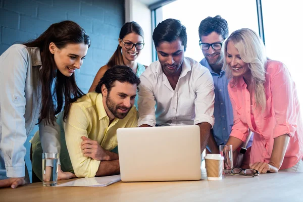 Groupe de collègues regardant un ordinateur portable — Photo