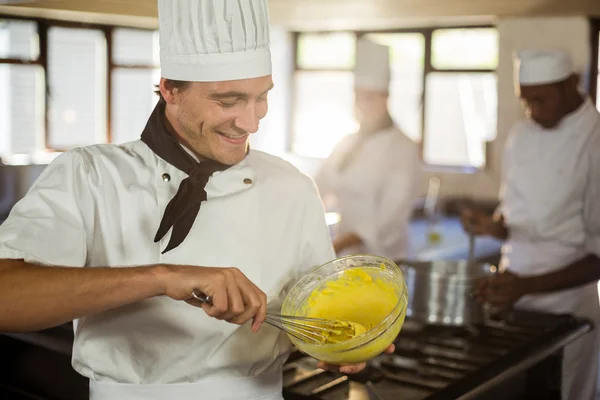 Chef sonriente mezclando masa —  Fotos de Stock