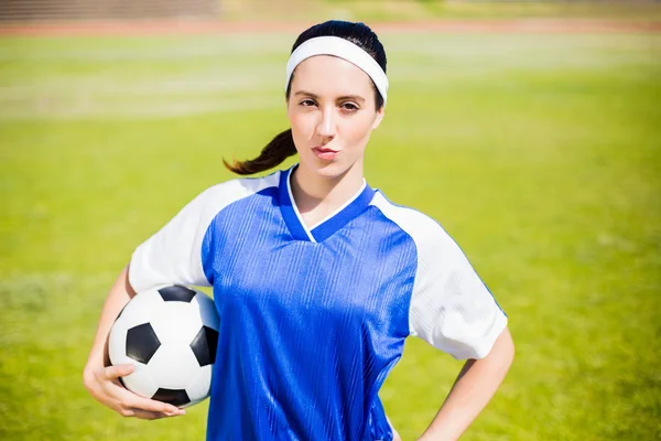 Säker fotbollspelare står med en boll — Stockfoto