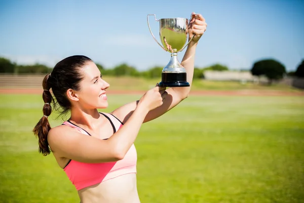 Feliz atleta feminina mostrando seu troféu — Fotografia de Stock