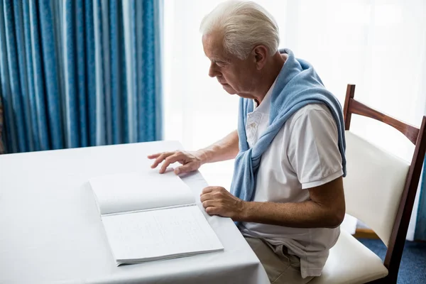 Uomo anziano che usa il braille per leggere — Foto Stock