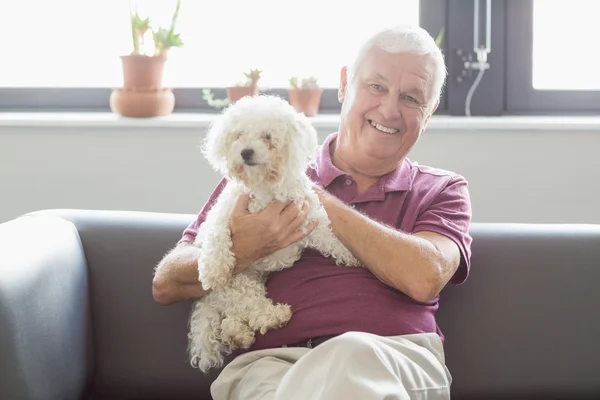 Senior homem segurando um cão — Fotografia de Stock