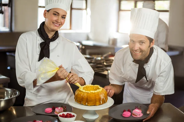 Two chefs preparing a cake — Stock Photo, Image