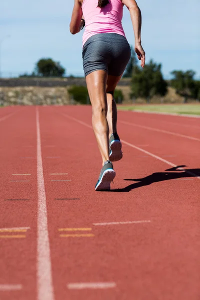 Visão traseira do atleta feminino correndo na pista de corrida — Fotografia de Stock