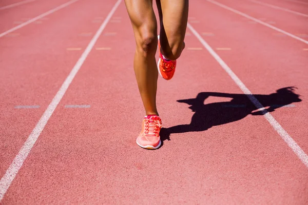 Atleta feminina correndo na pista de corrida — Fotografia de Stock