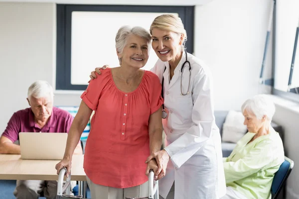 Verpleegkundige helpen senior met het lopen van de steun — Stockfoto