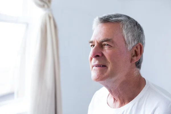 Thoughtful senior man in bedroom — Stock Photo, Image