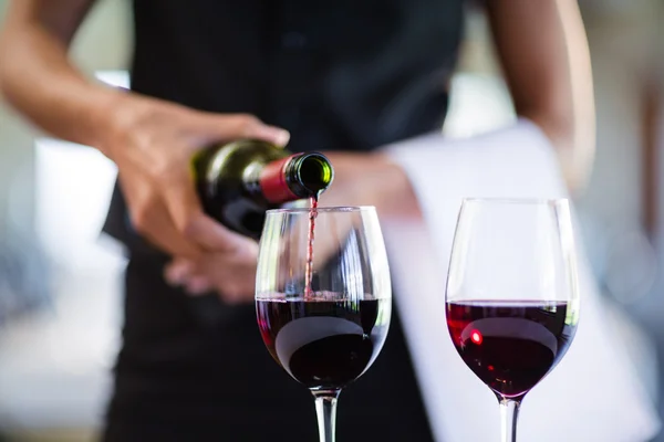 Servitrisen hälla rött vin i glas — Stockfoto