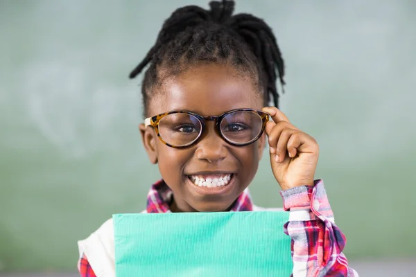 Schoolgirl holding file in classroom Royalty Free Stock Images