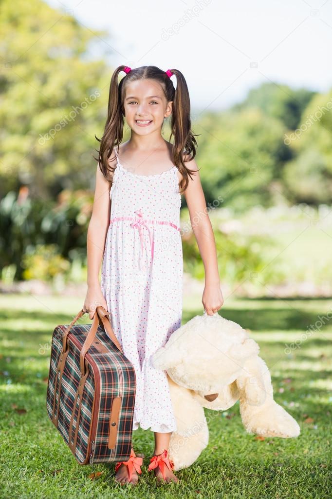 Girl holding suitcase and teddy bear — Stock Photo © Wavebreakmedia