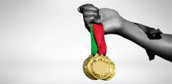 Mão segurando três medalhas de ouro — Fotografia de Stock