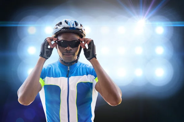 Cyklist poserar mot spotlights — Stockfoto