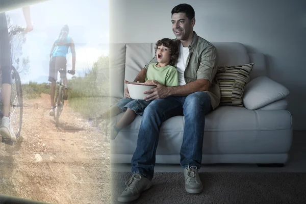Ojciec i syn oglądania, jazda na rowerze w telewizji — Zdjęcie stockowe