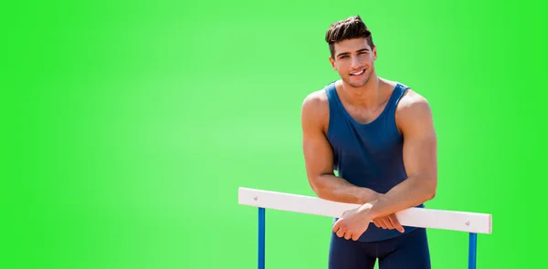 Sportsman smiling and posing on hurdle — Stock Photo, Image