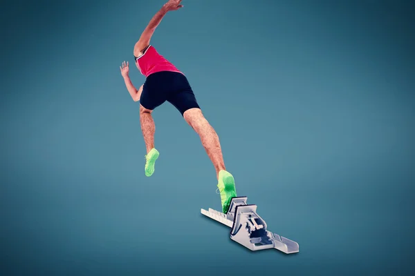 Male athlete running from starting blocks — Stock Photo, Image