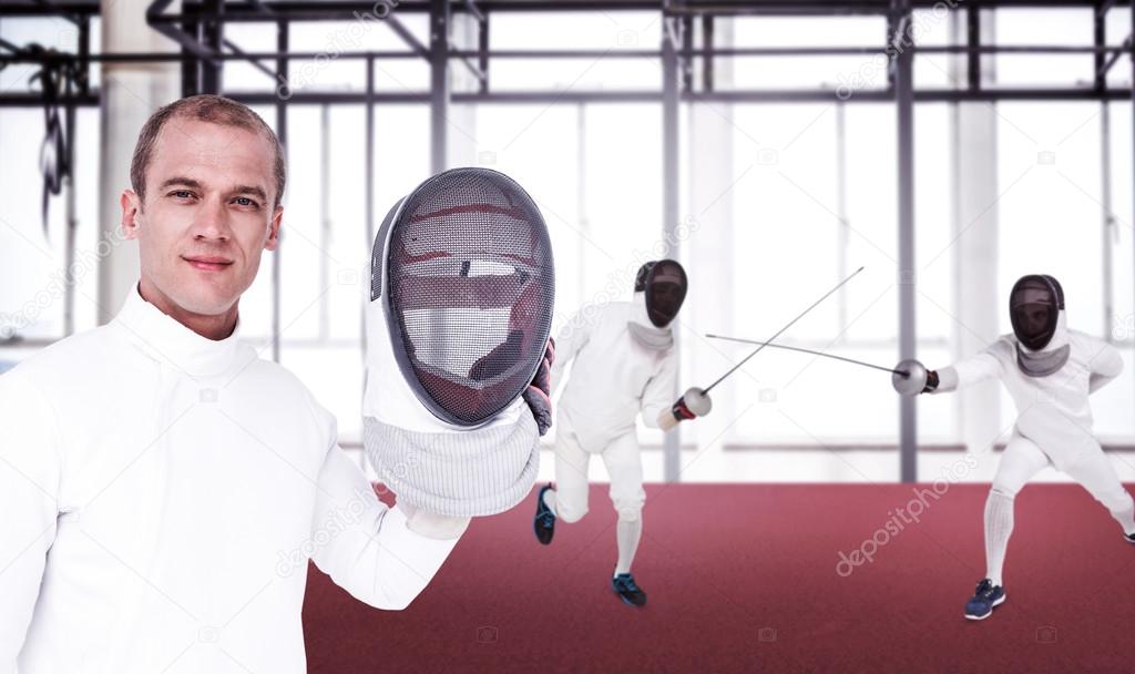Men in fencing suits practicing with swords Stock Photo by