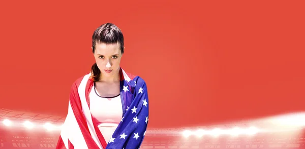 Mujer deportiva sosteniendo bandera americana — Foto de Stock