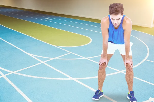 Atleta cansado de pie con la mano en la rodilla — Foto de Stock