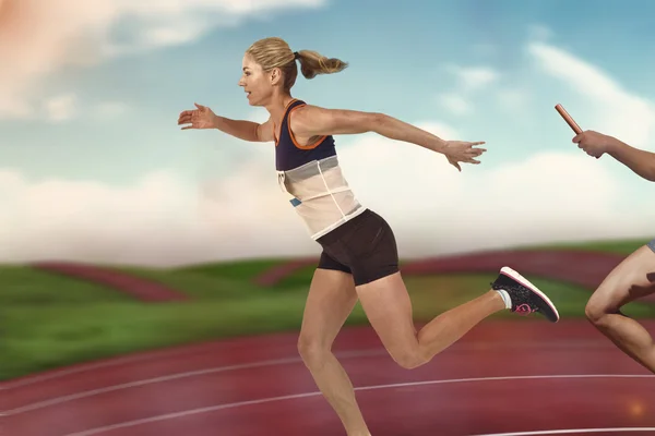 Athlete passing baton to partner — Stock Photo, Image