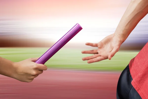 Atleta passando bastão para parceiro — Fotografia de Stock