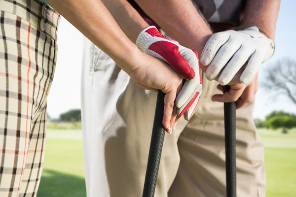 Hands holding golf clubs — Stock Photo, Image