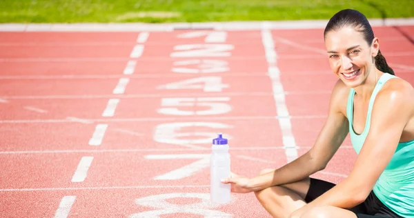 Sportlerin sitzt mit Fläschchen — Stockfoto