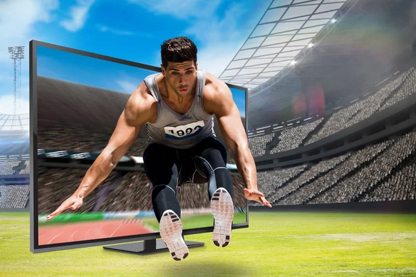 Sportsman jumping against stadium — Stock Photo, Image